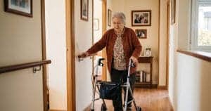 Prevención de caídas en personas mayores: anciano usando andador en el hogar